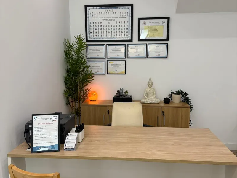 La mesa de la consulta, con dos sillas de madera y los títulos de Fran en la pared